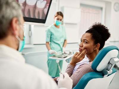 Patient with toothache looking at dentist in treatment chair