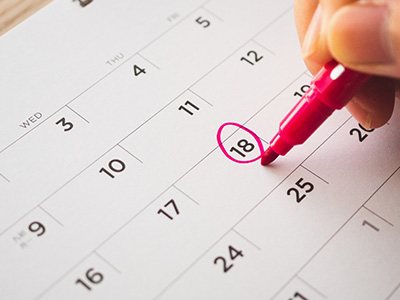 Someone circling the 18th of the month on their calendar with marker