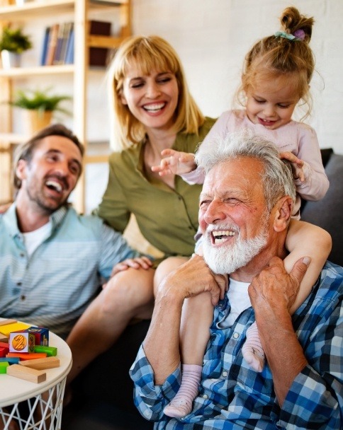 Parents laughing with their daughter and her grandfather