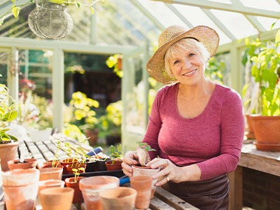 Happy senior woman working in greenhouse