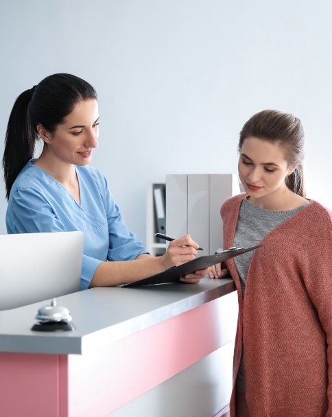 Dental team member showing a clipboard to a patient