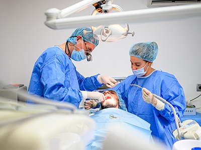 Team carefully performing dental implant surgery