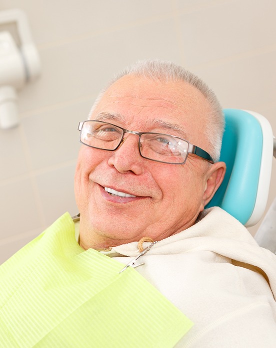Senior man sitting in dental chair smiling