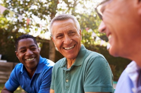 Three men laughing together outdoors