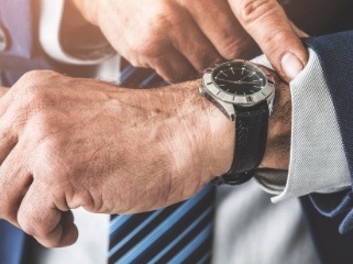 Close up of man in suit checking his wristwatch