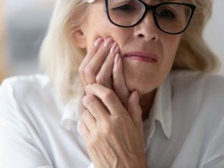 Woman holding her cheek in pain