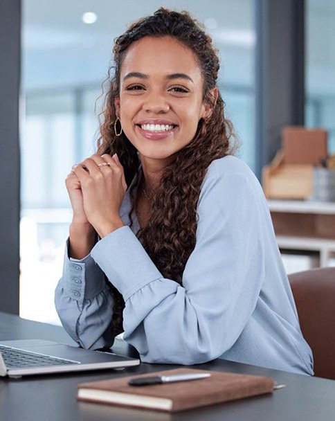 Woman smiling while working at desk in office