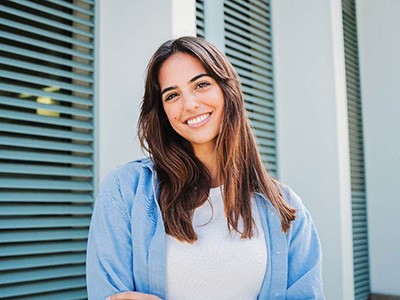 Woman with white teeth smiling while standing outside