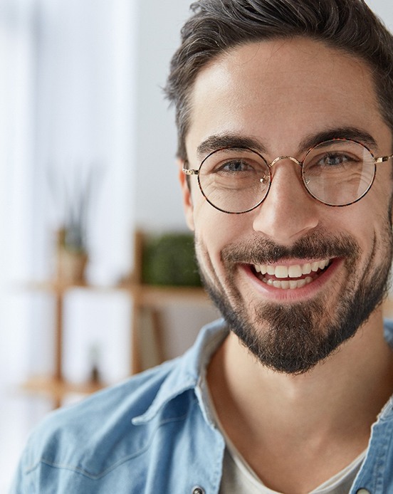 Man with beard and glasses smiling at home