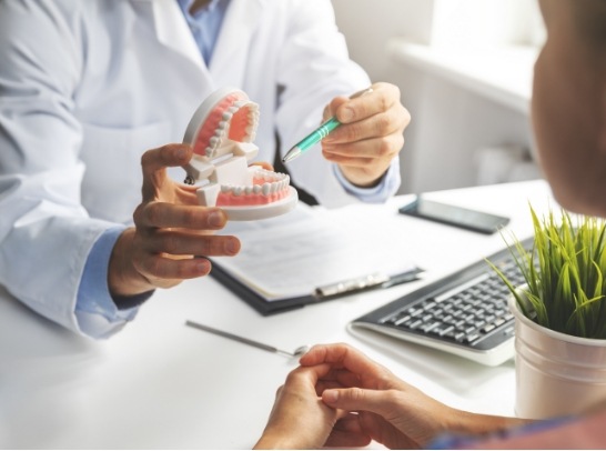 dentist showing teeth model to patient in Mesquite
