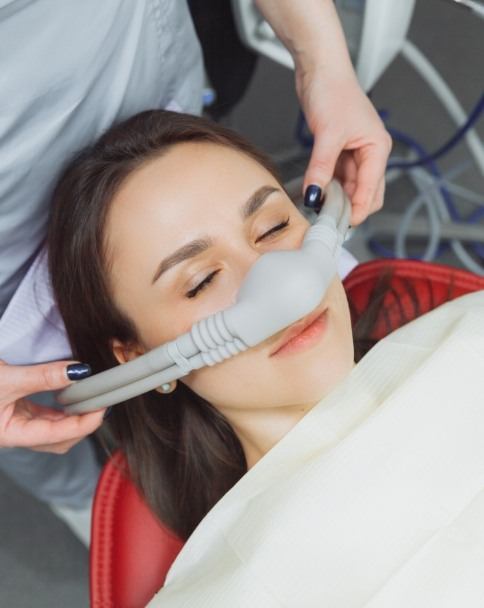 Woman relaxing in dental chair and wearing nitrous oxide mask